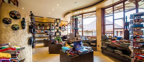 Una habitación amplia con techo curvo, un ventanal que ofrece vistas a las montañas y estantes llenos de libros y objetos decorativos.