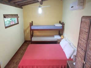 Un petit logement composé d’une seule pièce, comprenant un lit superposé et un lit simple.