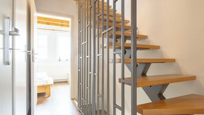 A staircase with wooden steps and metal railings, leading to an upper floor. - House Boddenkieker 2 Rügen Mönchgut, terrace with great lake view, Göhren. Sellin (Mönchgut)