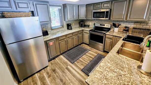 A modern kitchen with stainless steel appliances, granite countertops, and light wood flooring. - Ski-In Ski-Out Townhome | 2 Bedfroom | Shared Hot Tub | Fireplace | Parking (Mt. Crested Butte)