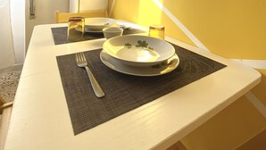 Una mesa de comedor con mantel blanco, un bol, un tenedor y una copa.
