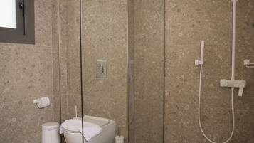 Un baño moderno con inodoro independiente, un bidé y una ducha.