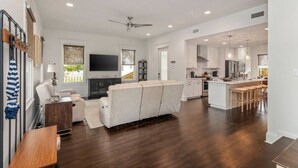 A spacious living room with a sofa, a flat-screen TV, and a fireplace.