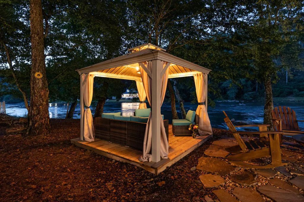 Un belvédère doté d’une terrasse en bois, de sièges confortables et offrant une vue sur l’eau.