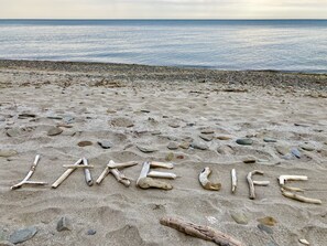 Uma praia com as palavras 'LAKE LIFE' formadas com pedras.