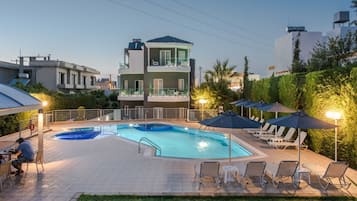 Una piscina al aire libre de temporada, sombrillas