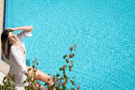 Una piscina al aire libre de temporada, sombrillas