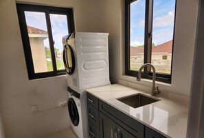 Enjoy a convenient kitchen with a washer and dryer, stainless steel sink, and a window offering a neighborhood view.