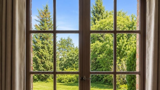 A double door with a view of a garden and patio furniture. - les jardins de Beaumont (Hem)