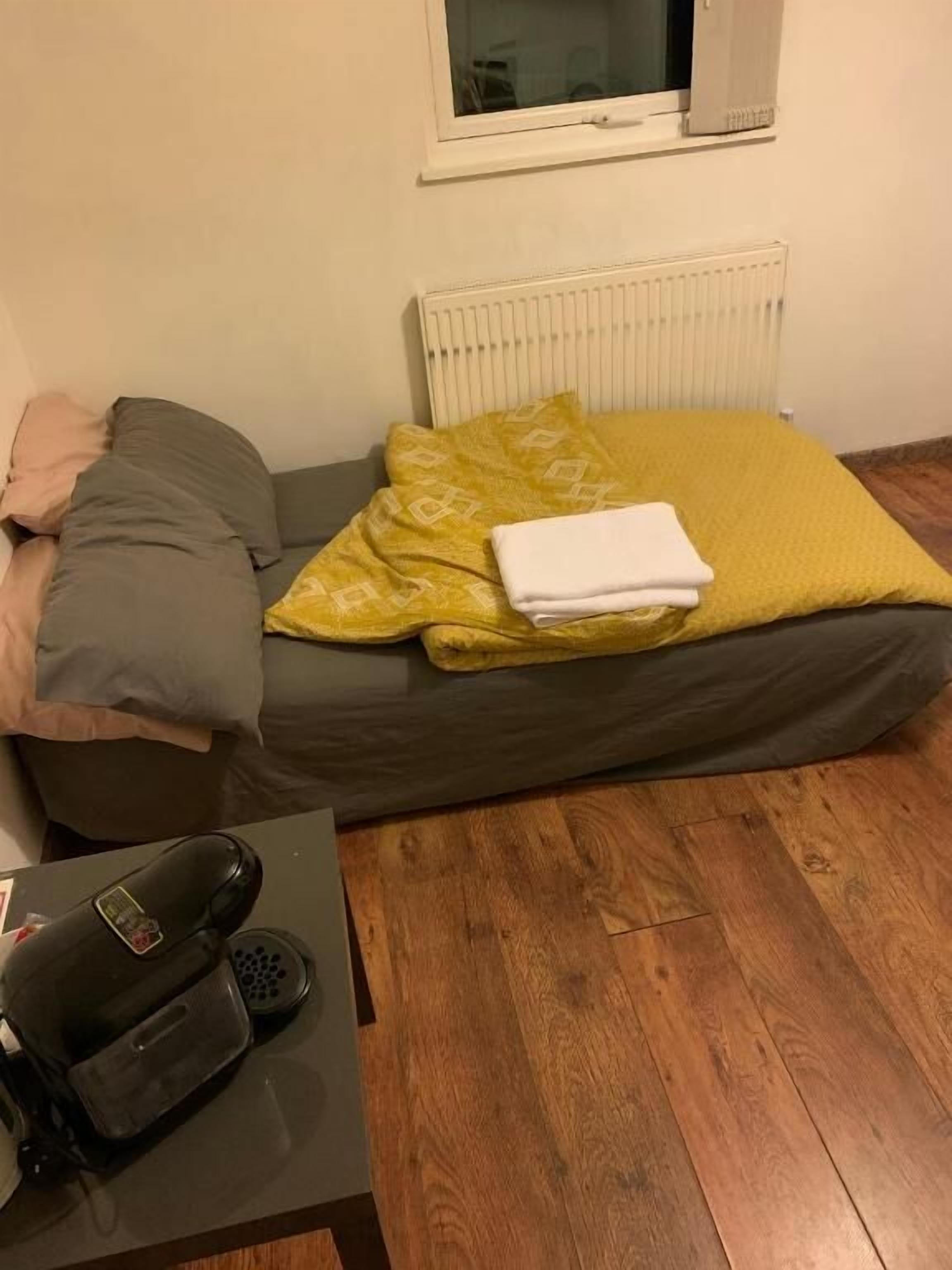 Une petite pièce agréable, avec un lit, un radiateur, une fenêtre et une table sur laquelle se trouve un téléphone.