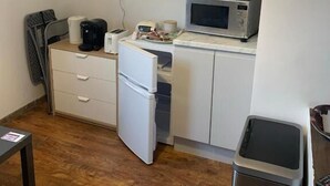Una cocina compacta equipada con microondas, tostadora y un refrigerador pequeño.