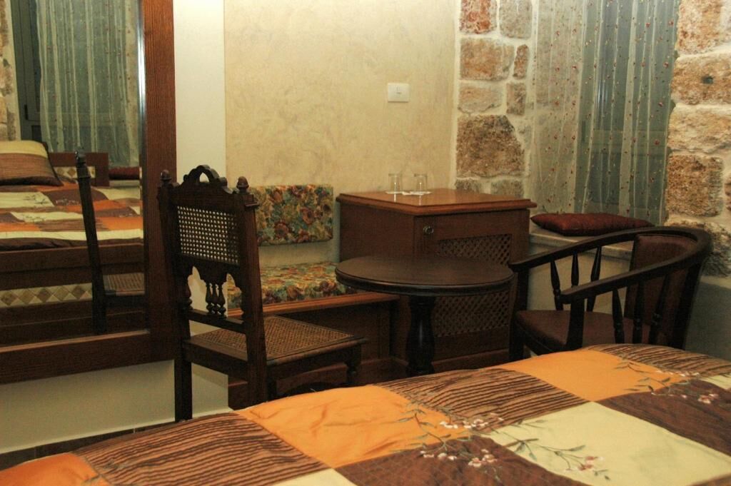 Una habitación con una cama, una mesa redonda y dos sillas.