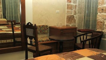 Una habitación con una cama, una mesa redonda y dos sillas.