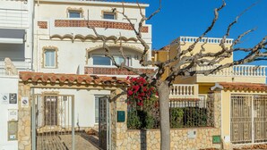 A two-story building with a stone facade, a gated entrance, and a balcony with a tiled roof. - V020 - Puerto Primero (Empuriabrava)
