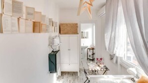 A bedroom with a bed, a desk, and a wardrobe. There is a star-shaped light fixture on the ceiling.