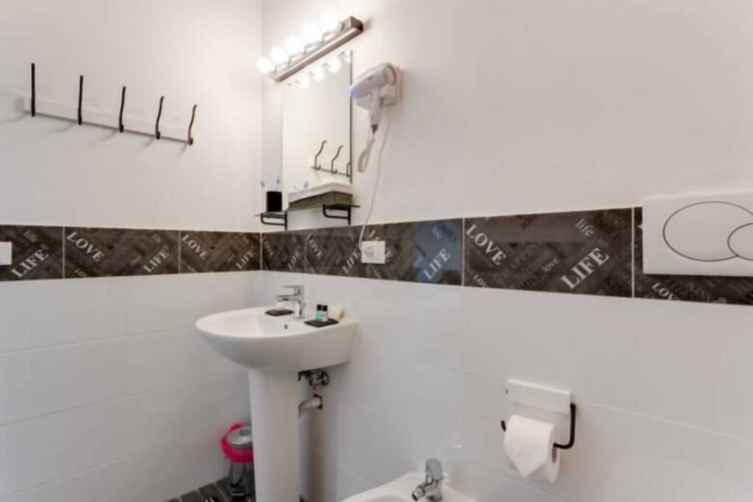 A bathroom with a sink, mirror, and towel rack.