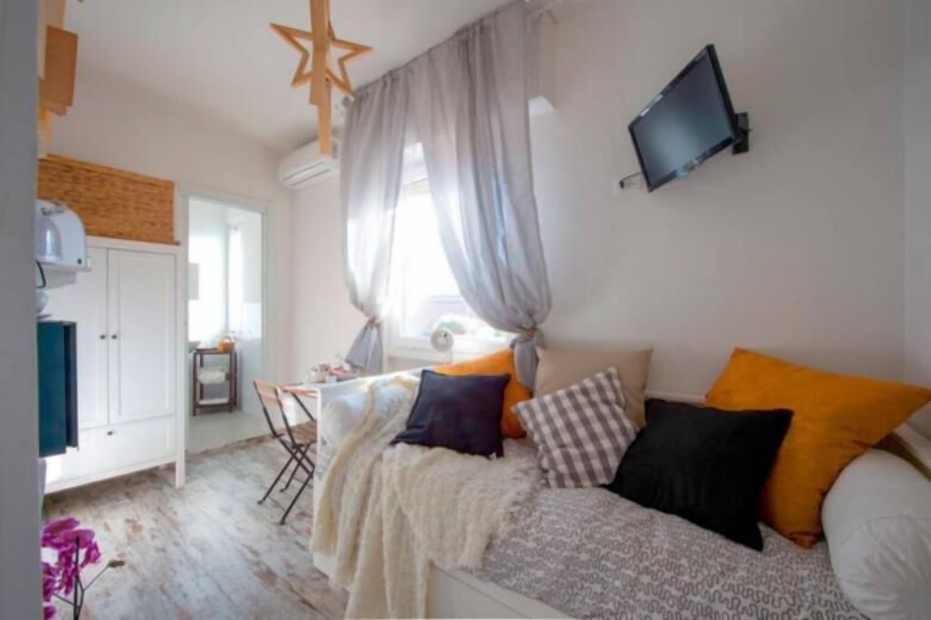 Un dormitorio con cama, escritorio y televisor.