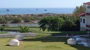 A coastal view with a grassy area, three spherical structures, and a building with a red roof. - Robin Apartment, Manta Rota, Algarve (Vila Nova de Cancela)