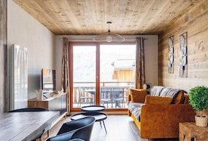 Cozy living space with a comfortable sofa, dining area, and large window offering a view of the outdoors.