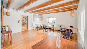 Une salle à manger spacieuse avec des poutres en bois, une grande table et des chaises.