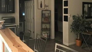 Una cocina moderna con microondas, encimera de madera y zona de comedor con sillas.