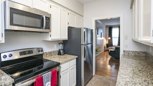A modern kitchen with stainless steel appliances, white cabinetry, and granite countertops. - "The Traveller" 2bd Townhome off WEST END! 8 min ->DT! (Nashville)