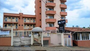 Un immeuble à plusieurs étages avec une enseigne indiquant « Apart Suites » et « The Hill ».