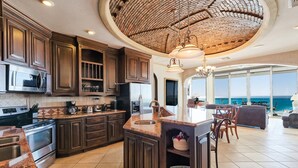 Una cocina amplia con armarios de madera oscura, electrodomésticos de acero inoxidable y una isla grande.