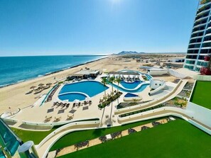 Un resort con piscina, acceso a la playa y vistas al océano.