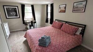 Une chambre à coucher avec un lit, un bureau et une chaise.
