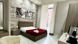 Une chambre moderne avec un grand lit, une table de chevet, une chaise et un bureau avec un miroir.