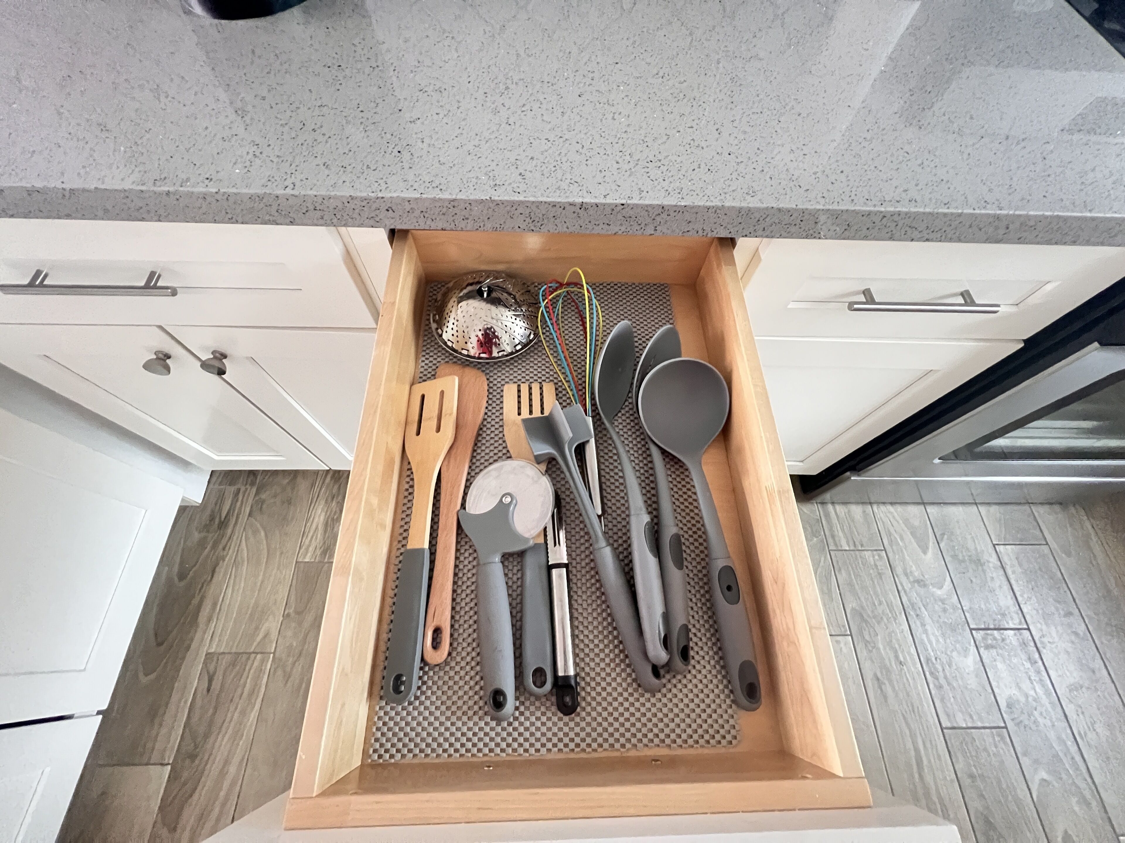 Un tiroir de cuisine contenant divers ustensiles, rangés de manière ordonnée.