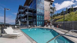 Ein modernes Hotel mit Dachpool, mehreren Balkonen und Blick auf die umliegende Landschaft.