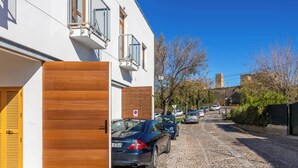 A cobblestone street lined with parked cars and a building with a wooden door and windows. - One of 3 identical  for 4 can be let together to sleep 12  opposite the Parador de Carmona - Casa Xanadu (Carmona)