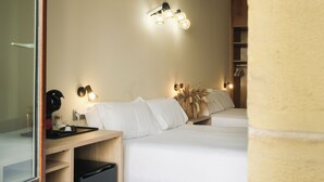 Habitació d'hotel amb dos llits, una taula de nit, una làmpada i una làmpada de paret.