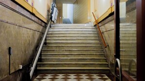 Una escala amb un paviment de pissos i un aterradís al final.