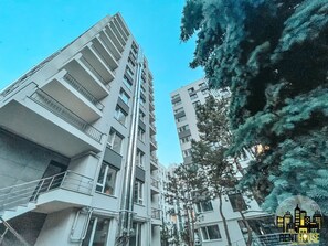 Stylish high-rise building with multiple balconies and a clean, geometric design.