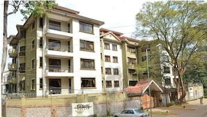 Useita kerroksia käsittävä rakennus, jossa on parvekkeita, portti ja kyltti, jossa lukee, että kyseessä on kiinteistö nimeltä ”FARMARI PALACE”.