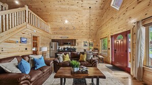 A wooden cabin interior with a living room, kitchen, and dining area. - Family Friendly Cabin, Mountain Views, Easy Roads, Pool, Hot Tub, Game Room (Gatlinburg)