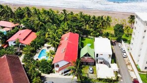 A coastal residential area with houses, a swimming pool, and a beach in the background. - Oceanfront Pool Paradise Villa (Provincia de Puntarenas)
