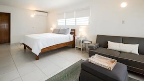 A bedroom with a bed, bedside table, nightstand, and a sofa. - Home in the heart of the city (Guaynabo)
