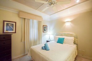 Una camera da letto con un letto, un comodino, una lampada, una ventola a soffitto e un armadio.