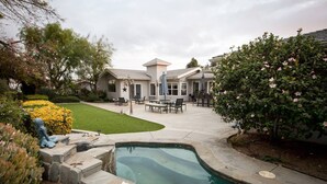 A residential backyard with a swimming pool, patio furniture, and a well-maintained lawn. - Elevate Your Wine Country Escape: Chick-Ranch with Luxurious Amenities, Views, Private Driver (Temecula)