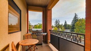 A balcony with a grill, a table, and a chair. - Old Town Loft Oasis With Amazing Rooftop Deck! (Fort Collins)