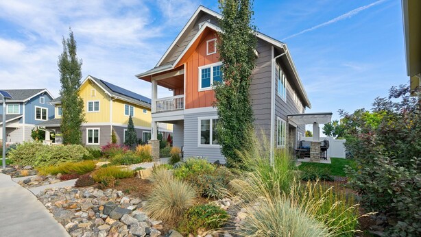 Una hilera de casas modernas con un jardín bien cuidado al frente.