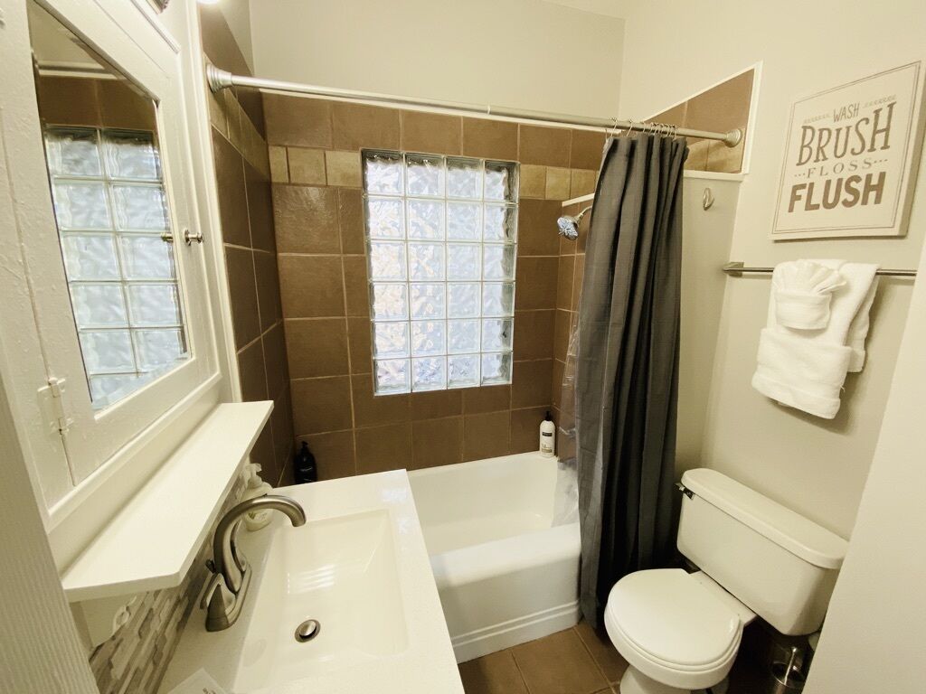 A bathroom with a bathtub, a toilet, and a sink.