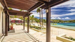 Un espacio al aire libre techado con vista a una playa y al océano.