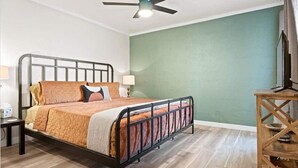 A bedroom with a bed, a nightstand, a lamp, a wooden side table, and a ceiling fan. - Modern and Sophisticated Old Town Scottsdale Gem! (Scottsdale)
