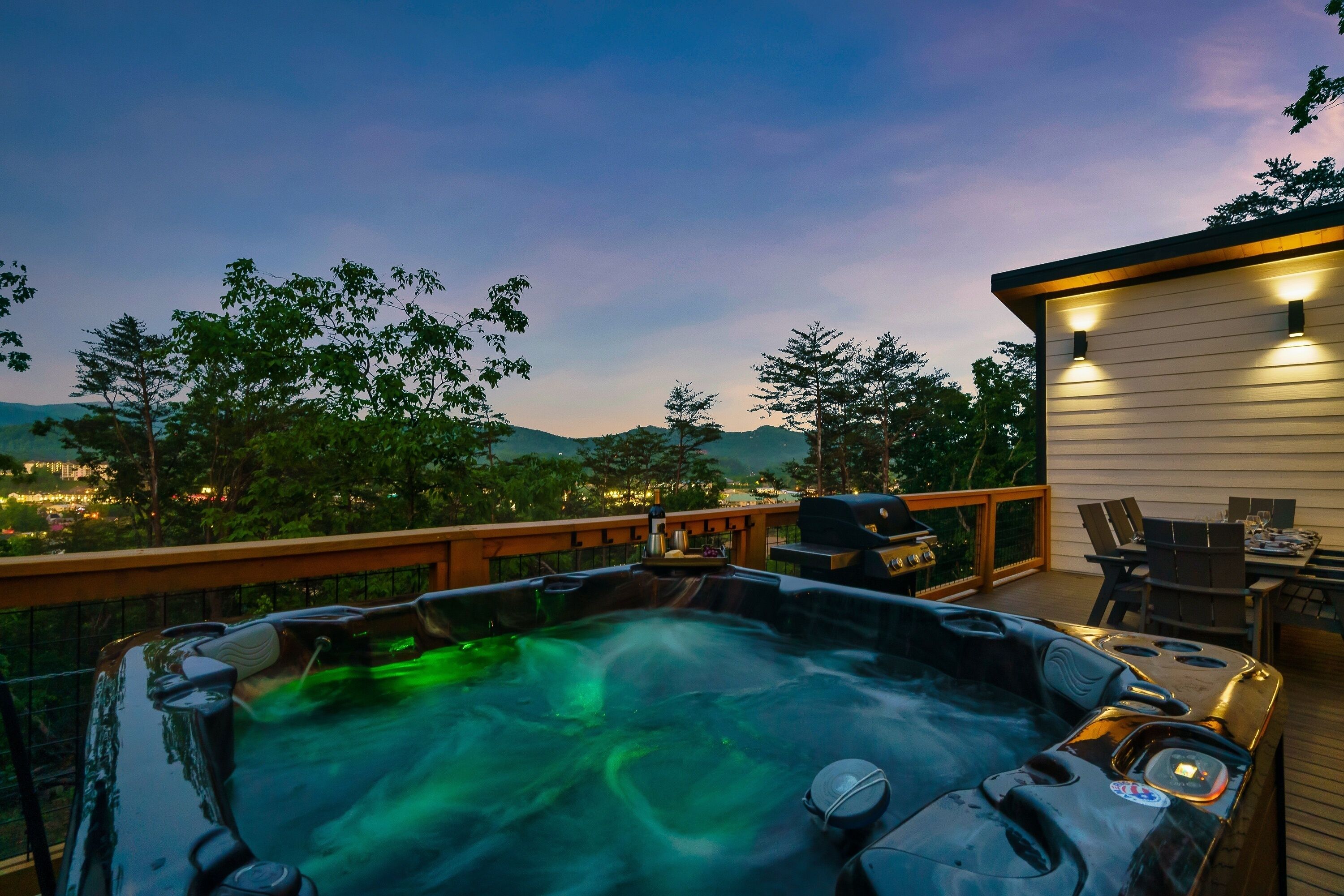 Een hottub op een terras met uitzicht op een stadsbeeld en bergen op de achtergrond.