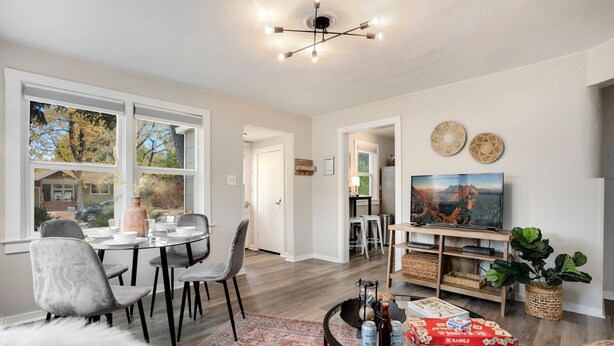 A modern living room with a dining area, a TV, and a fireplace. - Charming Old Town Bungalow W/ Free Cruiser Bikes (Fort Collins)